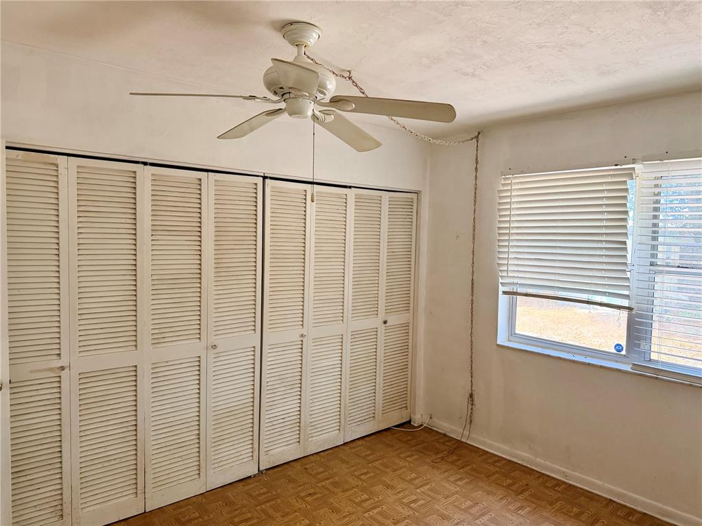 7055 Merrick Lane Spring Hill, FL 34606 - Photo 6 of 17 a view of empty room with wooden floor and fan