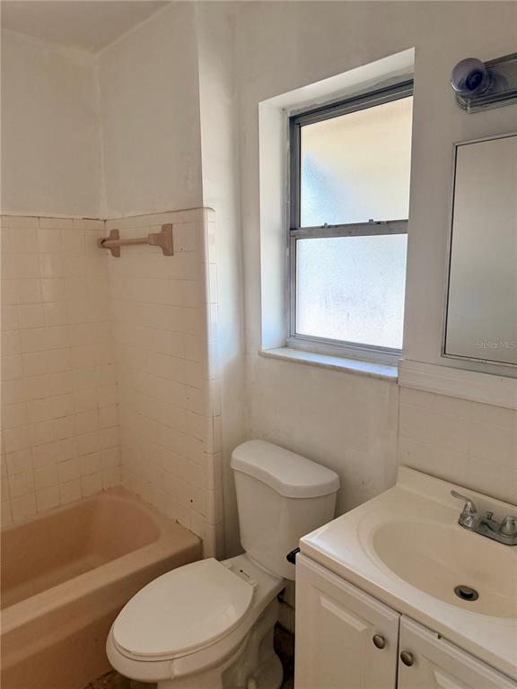 7055 Merrick Lane Spring Hill, FL 34606 - Photo 7 of 17 a white toilet and a window in a bathroom