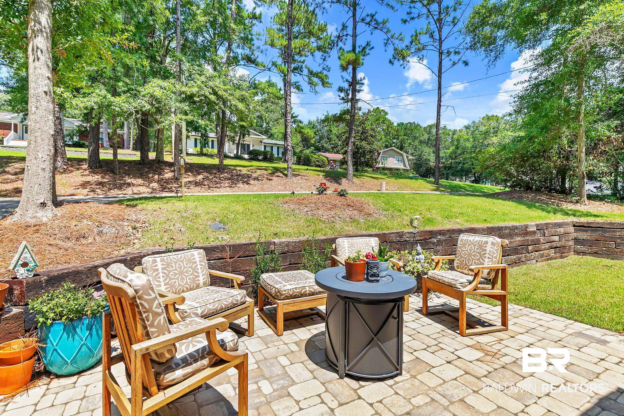 332 Ridgewood Drive Daphne, AL 36526 - Photo 6 of 48 View of patio featuring an outdoor fire pit and view of scattered trees