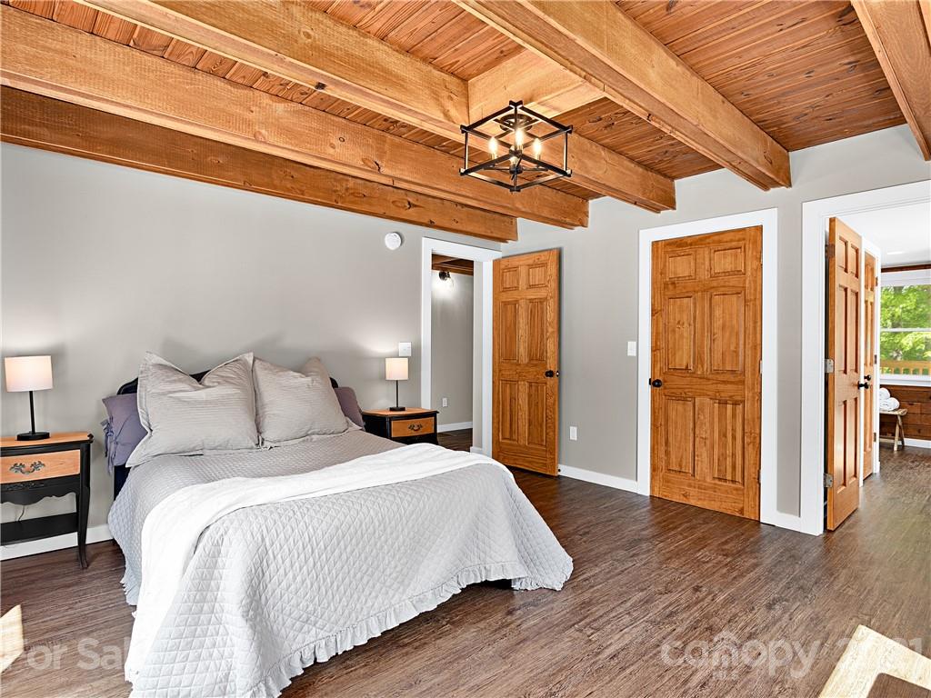 289 Laurel Ridge Road Canton, NC 28716 - Photo 14 of 32 a spacious bedroom with a bed and wooden floor