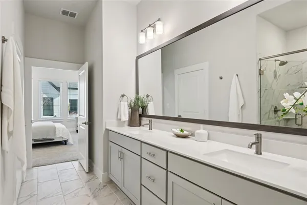 a en suite bathroom with a double sink and mirror