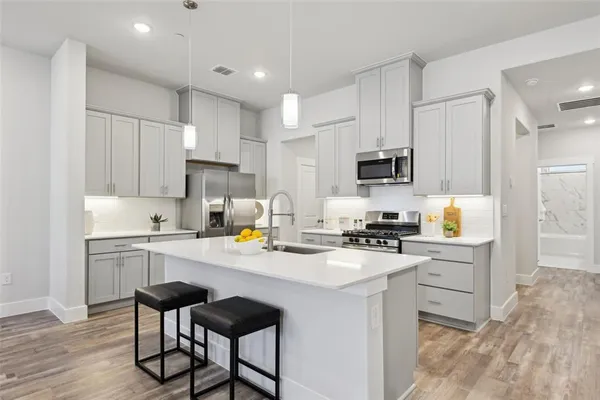 a kitchen with a stove a sink and a refrigerator