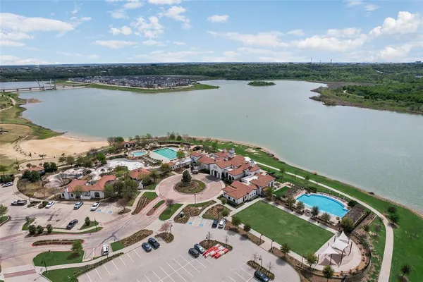 an aerial view of a house with outdoor space and a lake view in back