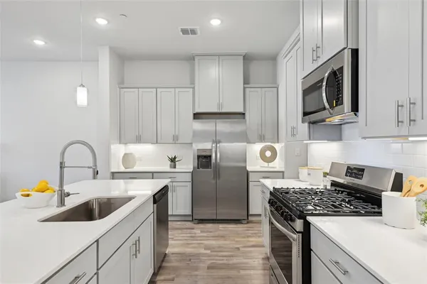 a kitchen with stainless steel appliances granite countertop a sink stove and refrigerator