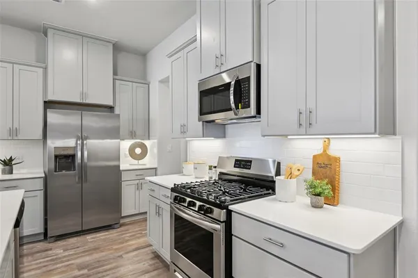 a kitchen with stainless steel appliances granite countertop a stove a refrigerator and a microwave