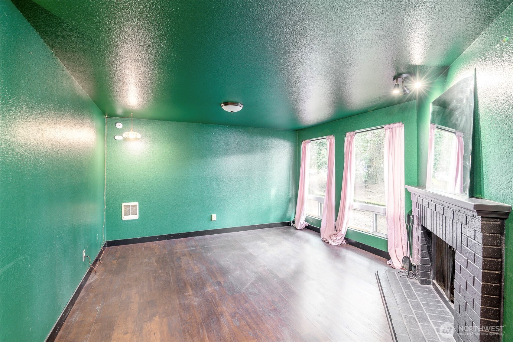 110 Southwest 116th Street, Unit A13 Seattle, WA 98146 - Photo 4 of 16 a view of empty room with a fireplace and a wooden floor