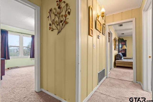 a view of a hallway with a livingroom and furniture
