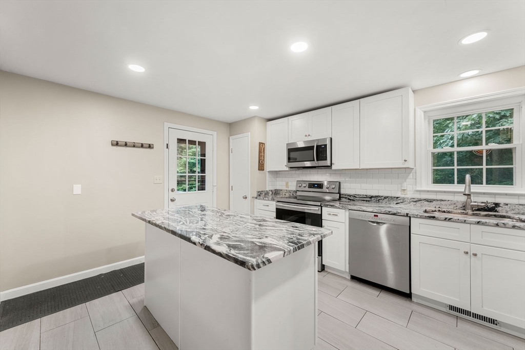 25 Holly Drive Gardner, MA 01440 - Photo 8 of 32 a kitchen with granite countertop white cabinets and white appliances