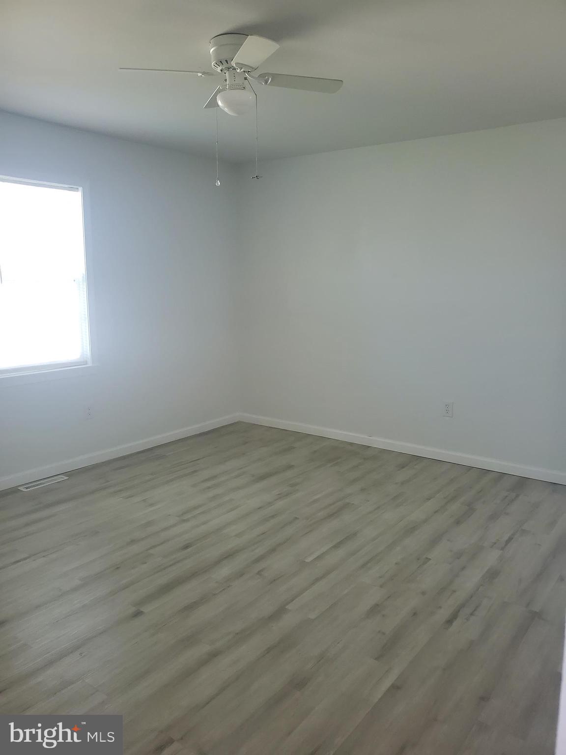 112 Holmes Street Dover, DE 19901 - Photo 17 of 24 an empty room with wooden floor and windows