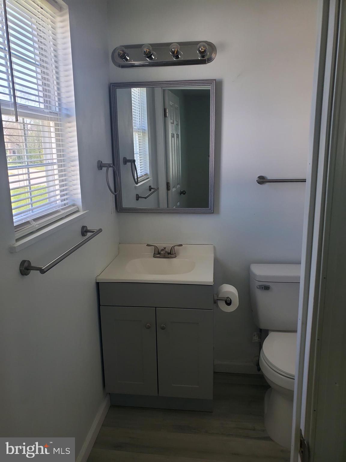 112 Holmes Street Dover, DE 19901 - Photo 18 of 24 a bathroom with a toilet sink vanity and mirror