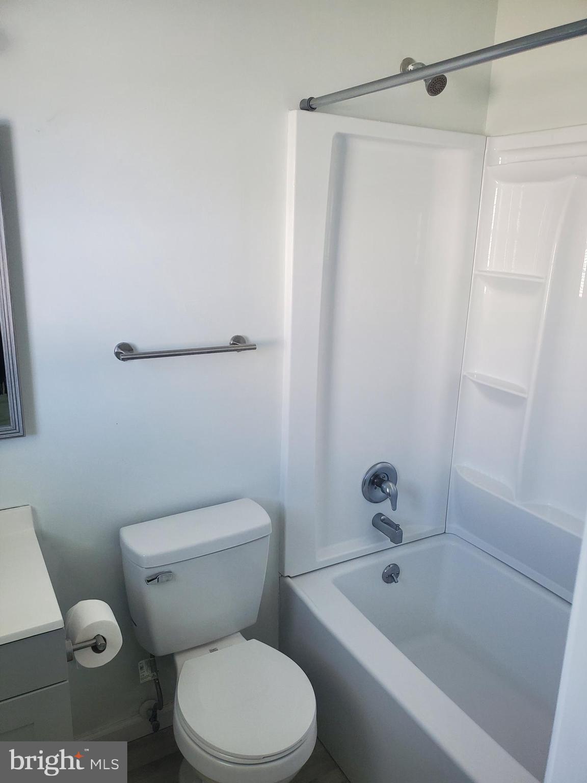 112 Holmes Street Dover, DE 19901 - Photo 19 of 24 a white toilet and shower sitting next to a bathroom sink