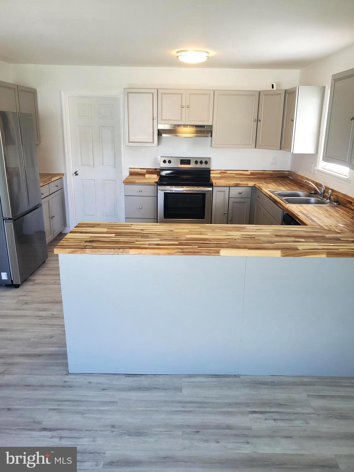 112 Holmes Street Dover, DE 19901 - Photo 2 of 24 a white kitchen with wooden floors