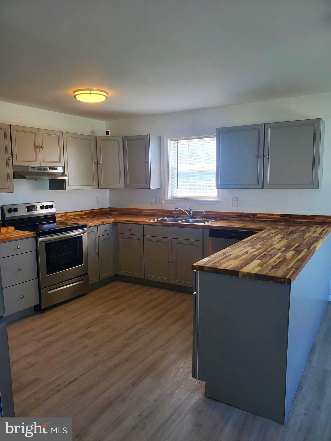 112 Holmes Street Dover, DE 19901 - Photo 7 of 24 a kitchen with stainless steel appliances granite countertop a sink and a stove