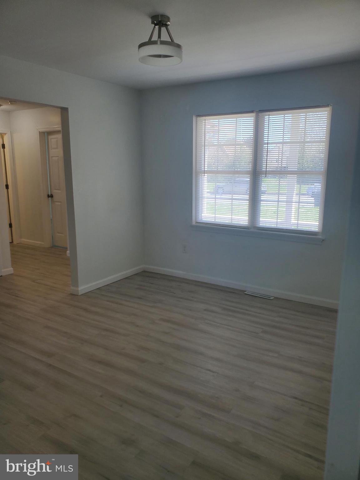 112 Holmes Street Dover, DE 19901 - Photo 10 of 24 an empty room with wooden floor and windows
