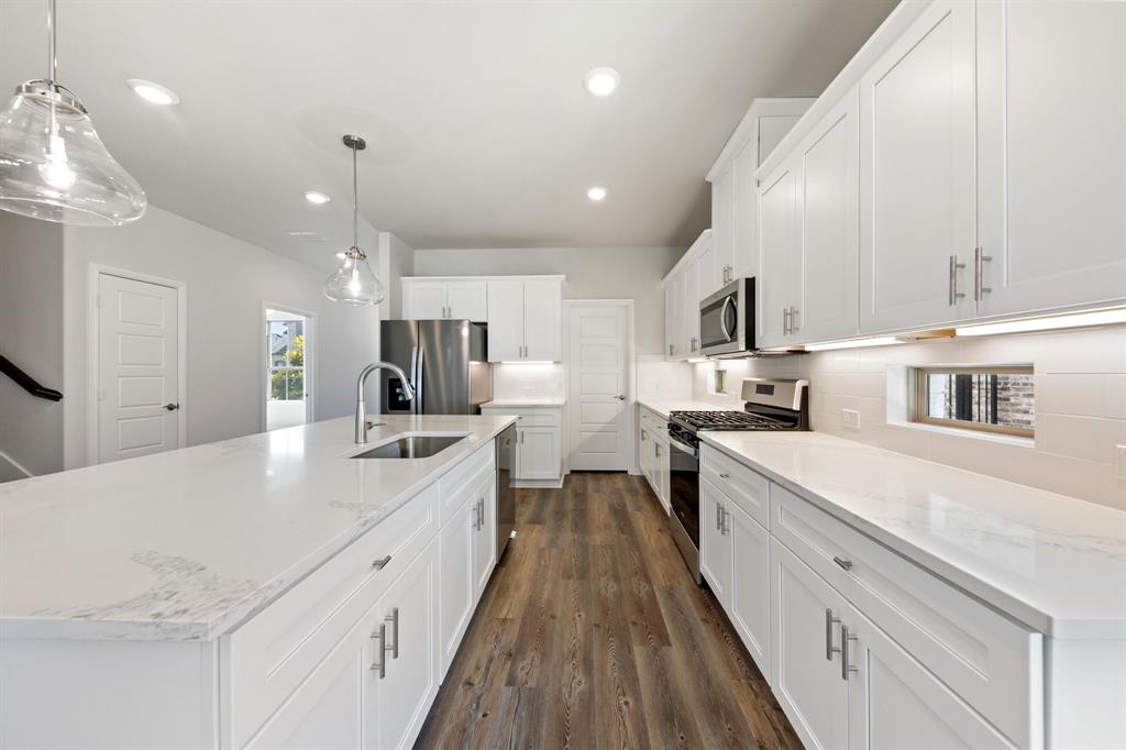 1844 Rosedale Avenue Van Alstyne, TX 75495 - Photo 7 of 26 A beautiful crisp clean white color palette and striking dark flooring effortlessly pair with contemporary stainless steel to create a kitchen for the ages!