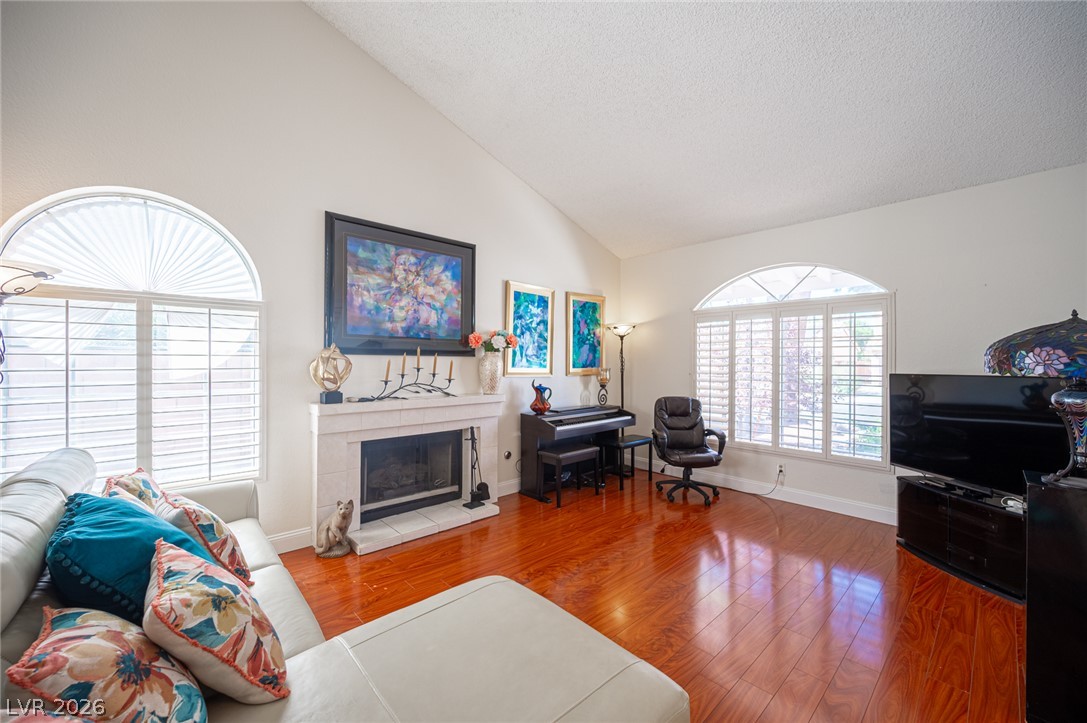 718 Rusty Spur Drive Henderson, NV 89014 - Photo 5 of 50 Bright hardwood flooring flows through this airy living room, anchored by an inviting fireplace and vaulted ceilings.
