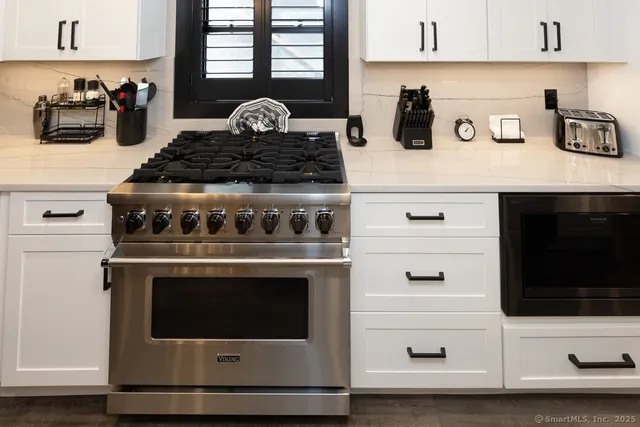 a stove top oven sitting inside of a kitchen