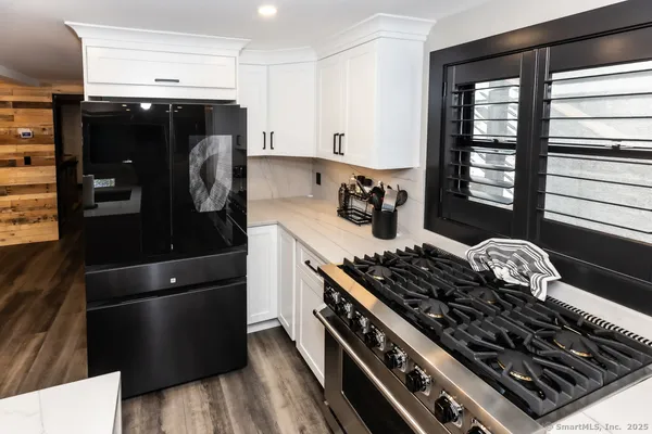 a kitchen with stainless steel appliances granite countertop a sink stove and refrigerator