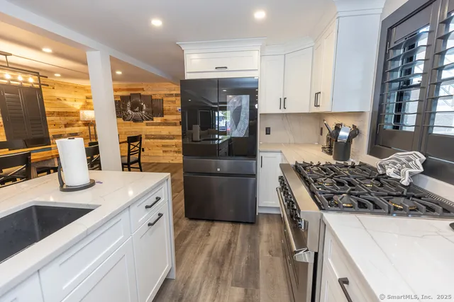 a kitchen with stainless steel appliances cabinets and a wooden floor