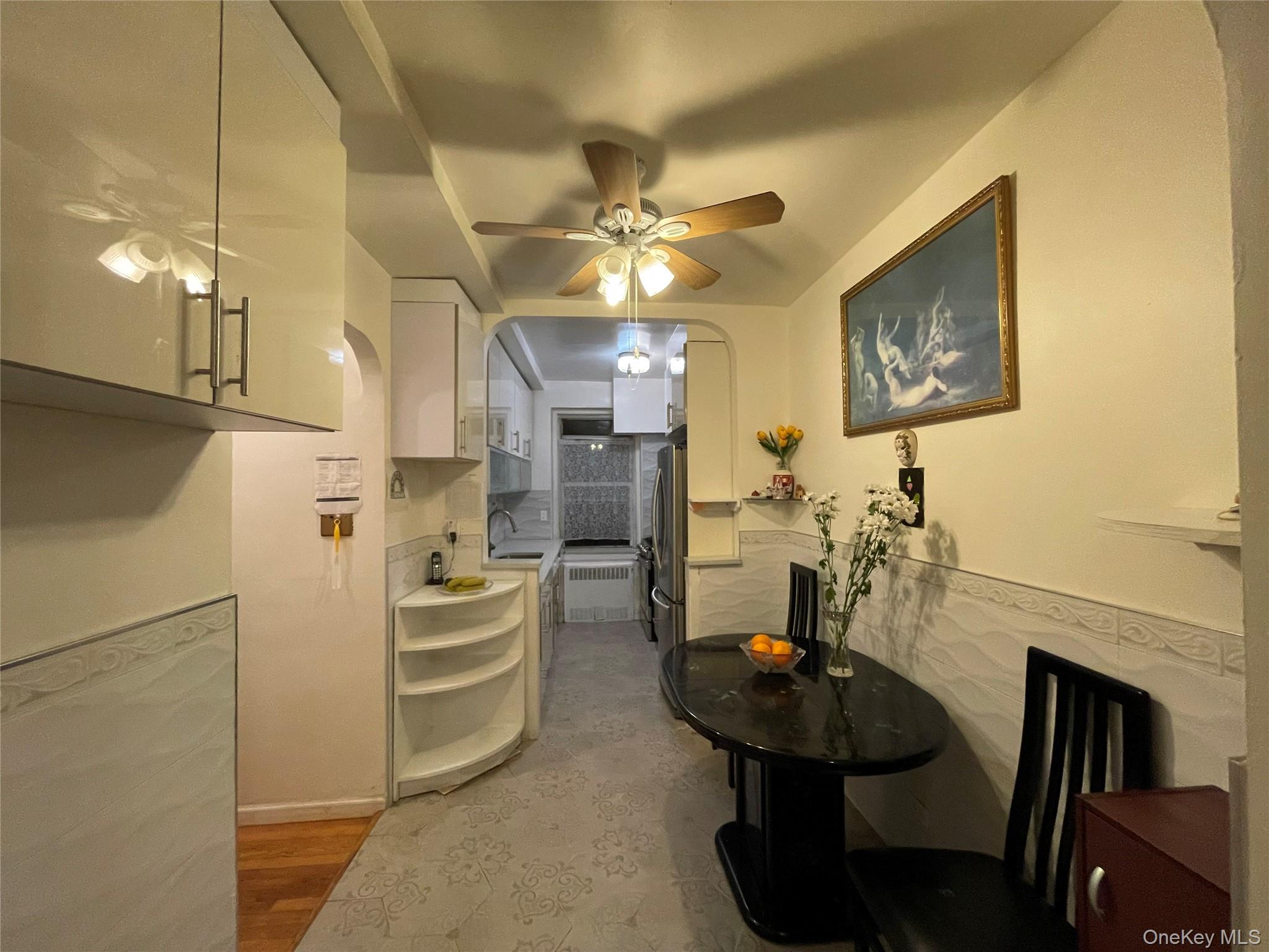 63-60 102nd Street, Unit D7 Queens, NY 11374 - Photo 2 of 41 Dining space featuring arched walkways, ceiling fan, and radiator heating unit