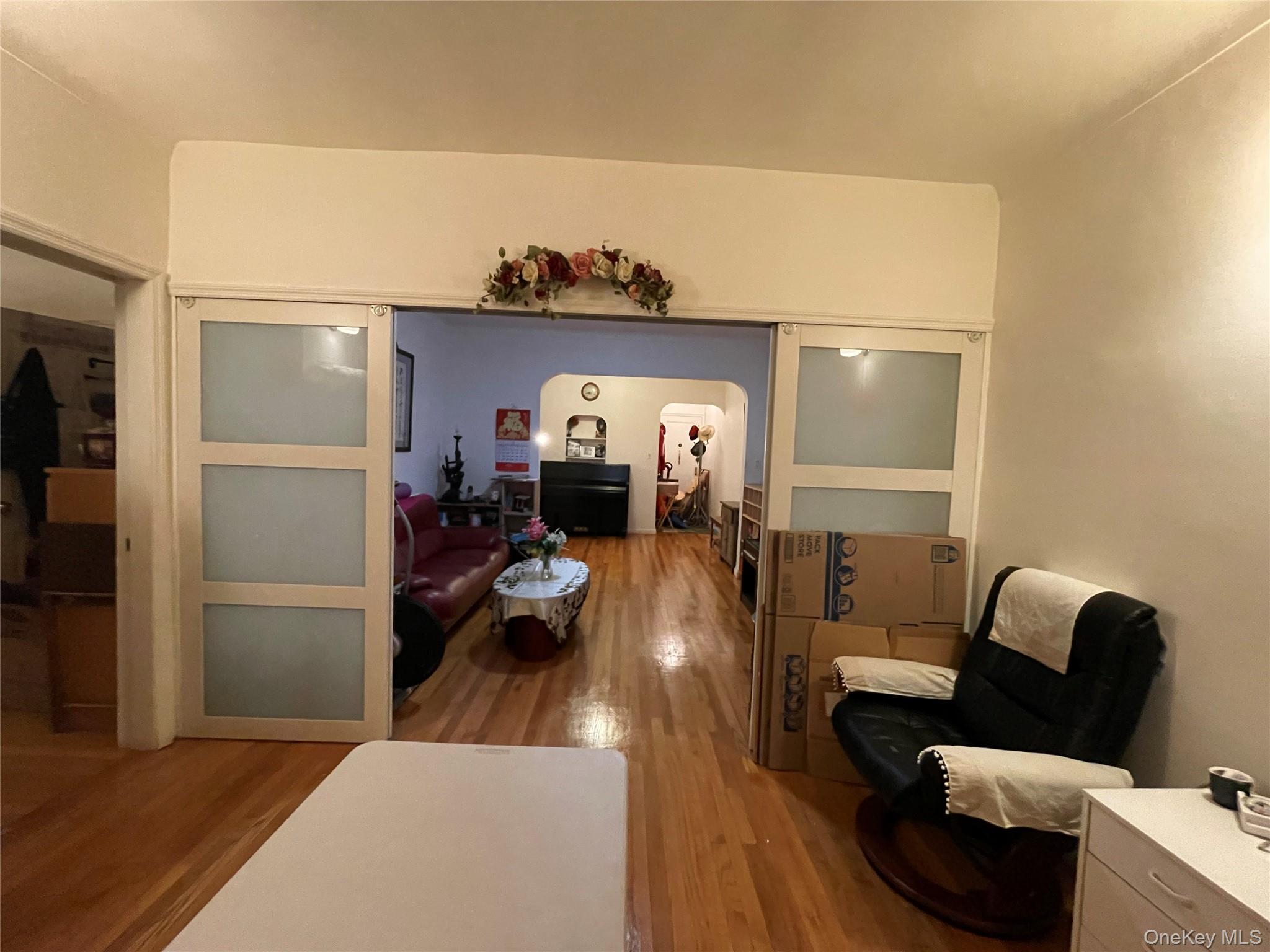 63-60 102nd Street, Unit D7 Queens, NY 11374 - Photo 29 of 41 Living room featuring arched walkways and wood finished floors