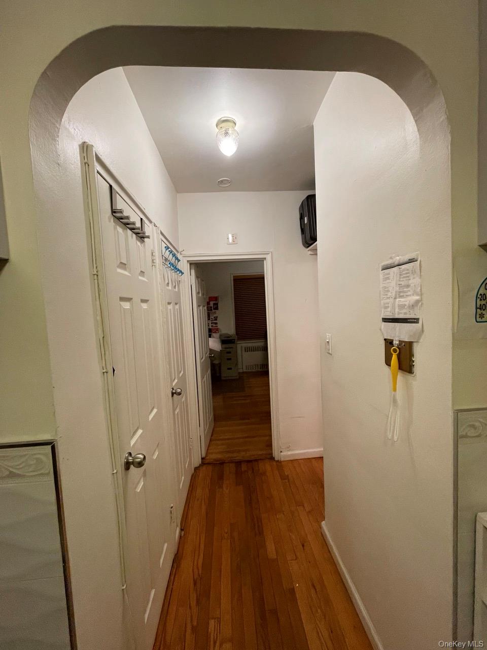63-60 102nd Street, Unit D7 Queens, NY 11374 - Photo 33 of 41 Corridor featuring dark wood-style flooring, arched walkways, and radiator heating unit