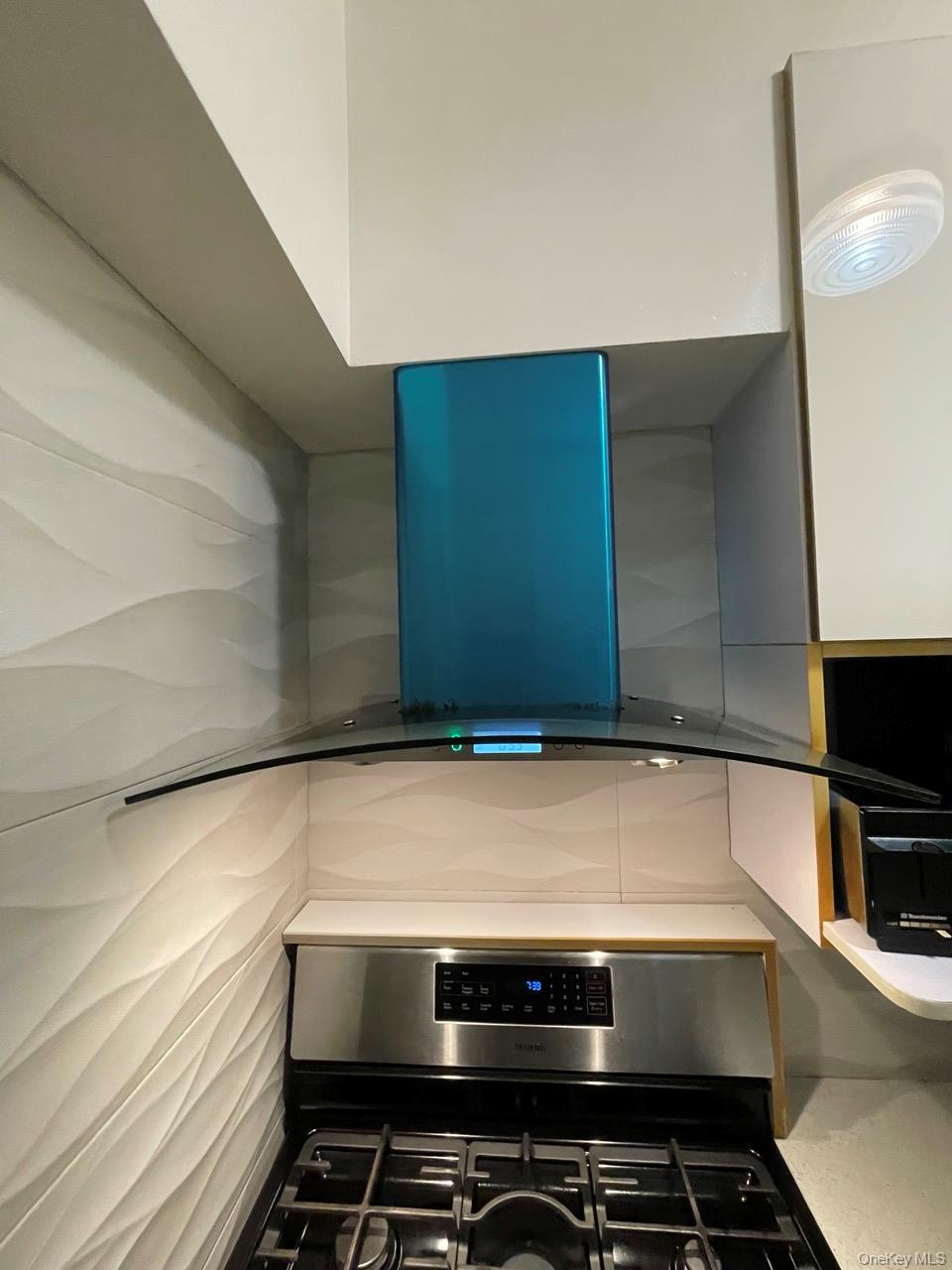 63-60 102nd Street, Unit D7 Queens, NY 11374 - Photo 37 of 41 Kitchen view of stainless steel gas range oven, exhaust hood, and white cabinetry