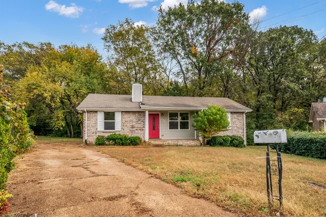 a front view of a house with a yard and potted plants