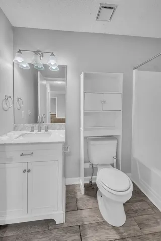 a bathroom with a toilet a sink and mirror