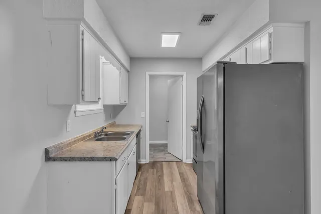 a kitchen with a refrigerator and a stove top oven