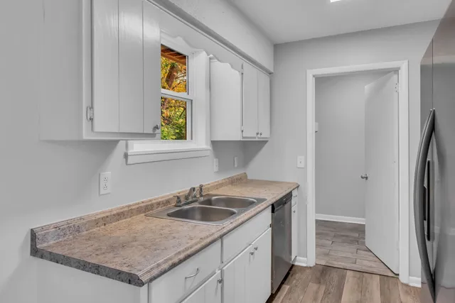 a kitchen with a sink a refrigerator and window