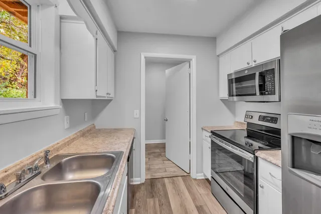 a kitchen with granite countertop a sink and steel appliances
