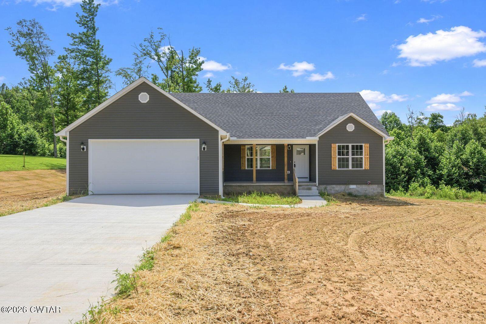 435 Old Huntingdon Road Lexington, TN 38351 - Photo 22 of 26 a front view of a house with a yard and garage