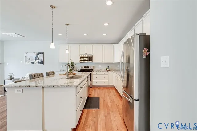 a kitchen with a refrigerator a sink and cabinets