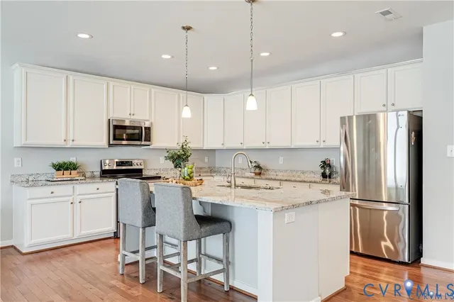 a kitchen with stainless steel appliances granite countertop a refrigerator a stove a sink and a microwave