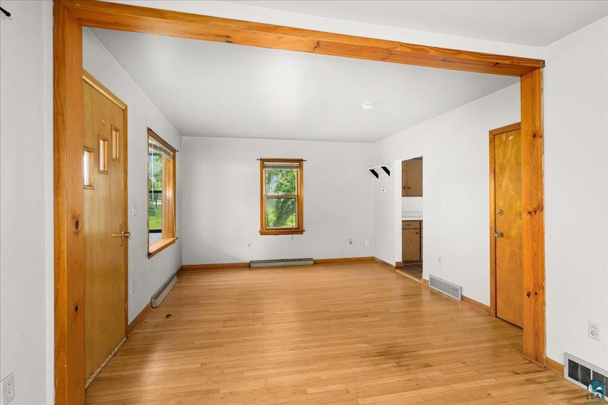 424 East Upham Road Duluth, MN 55811 - Photo 4 of 38 Hardwood-finish flooring throughout, featuring a natural wood door with panel windows, and two large windows with natural wood trim