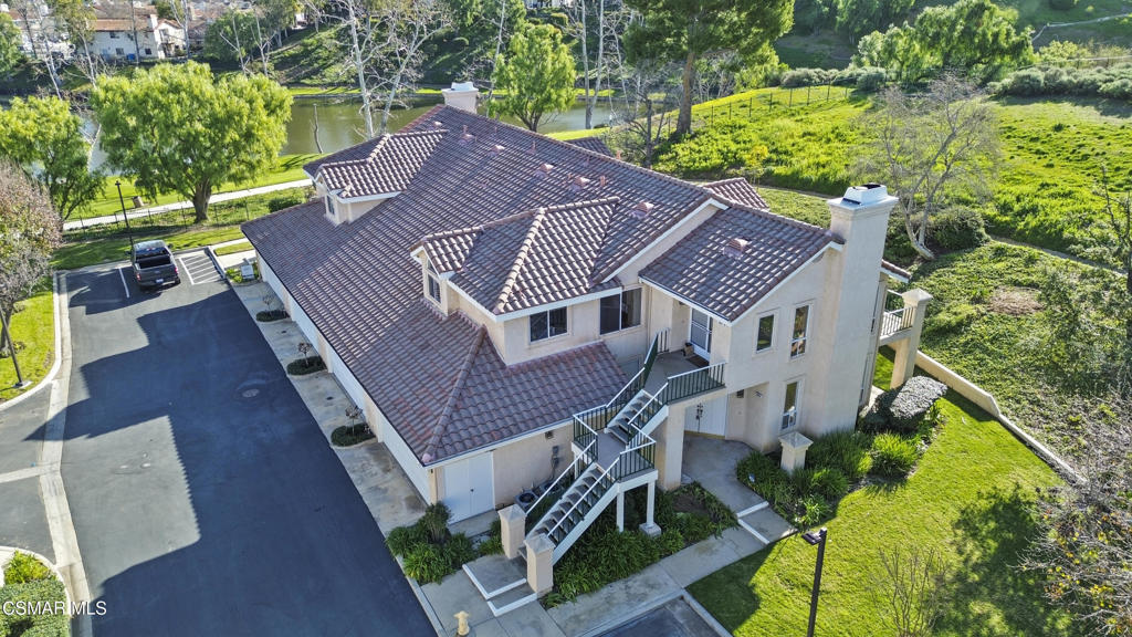 an aerial view of a house with a yard balcony and furniture