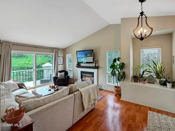 a living room with furniture fireplace and a large window