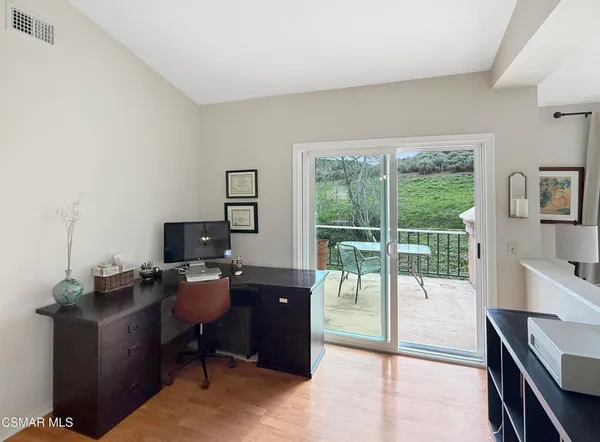 a view of a workspace with furniture and a window