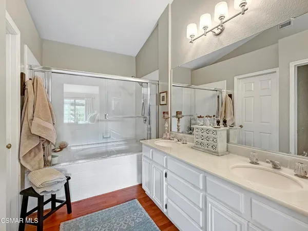 a spacious bathroom with a double vanity sink a mirror a bathtub and a shower