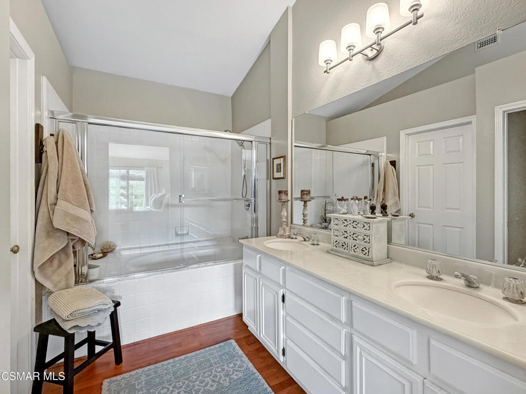 264 Ridgeton Lane, Unit B Simi Valley, CA 93065 - Photo 28 of 32 a spacious bathroom with a double vanity sink a mirror a bathtub and a shower