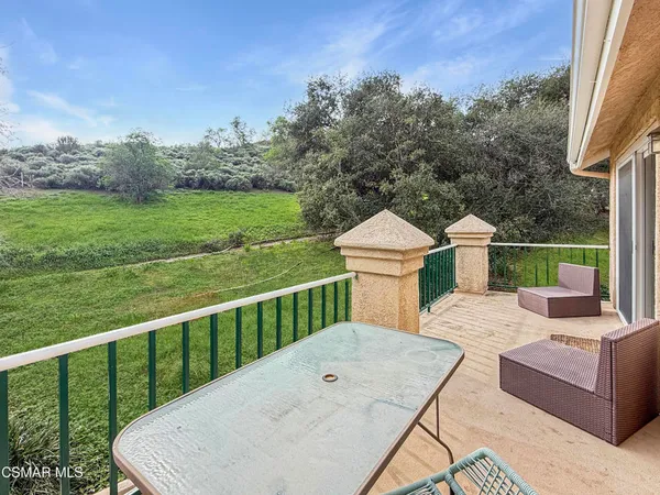 a view of a deck with a floor to ceiling window next to a yard