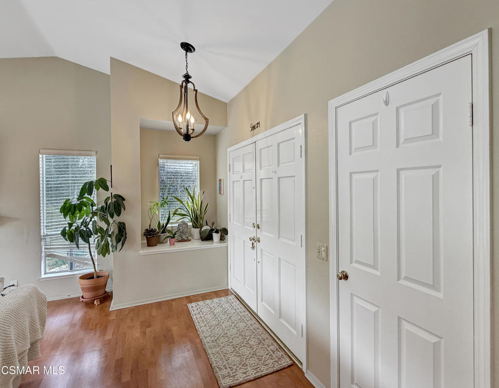 264 Ridgeton Lane, Unit B Simi Valley, CA 93065 - Photo 10 of 32 a view of a hallway with wooden floor and a chandelier