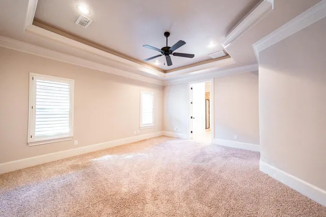 a view of a room with a ceiling fan and window