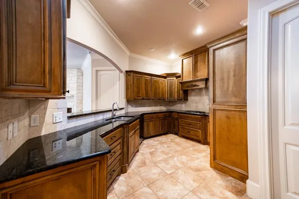 a kitchen with granite countertop a refrigerator stove and sink