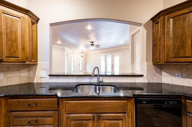 a kitchen with granite countertop a sink and cabinets