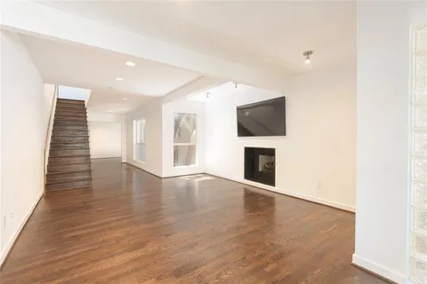 an empty room with wooden floor and fireplace