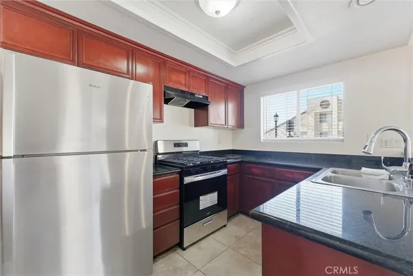 a kitchen with stainless steel appliances granite countertop a refrigerator a sink and a stove
