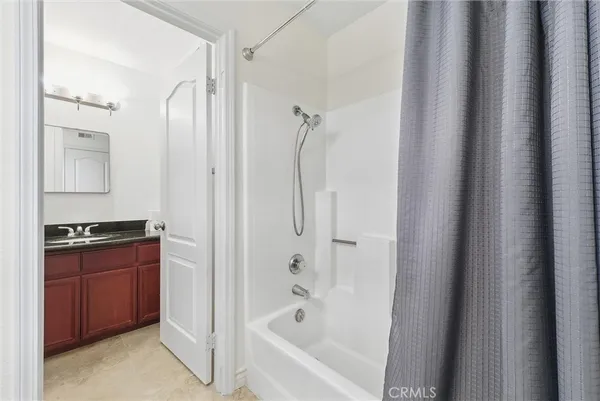 a bathroom with a tub sink shower and mirror
