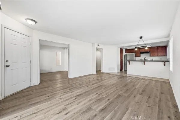 a view of a kitchen with a wooden floor and a refrigerator